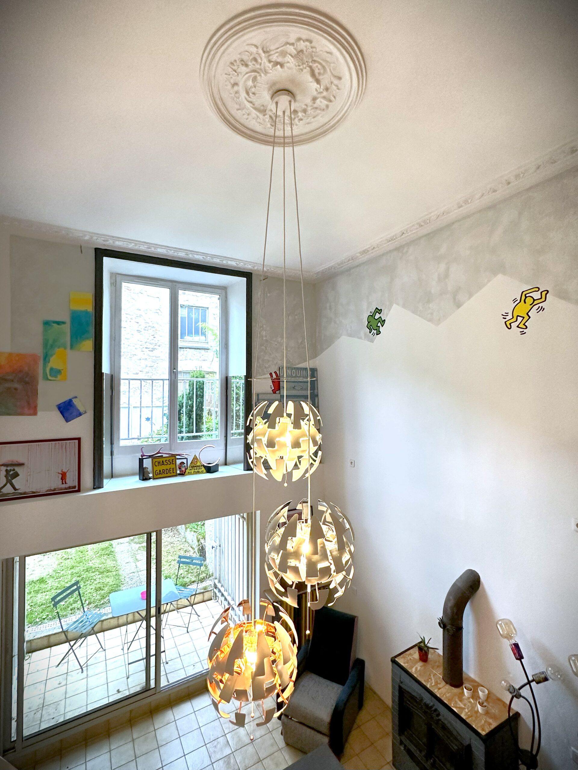 Vue d'un salon d'un loft de 2 étages avec lustres imposants.