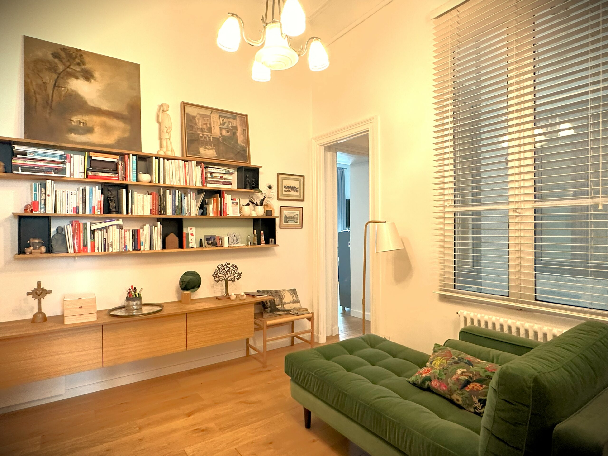 Bureau avec méridienne verte. Bibliothèque de livres et décoration