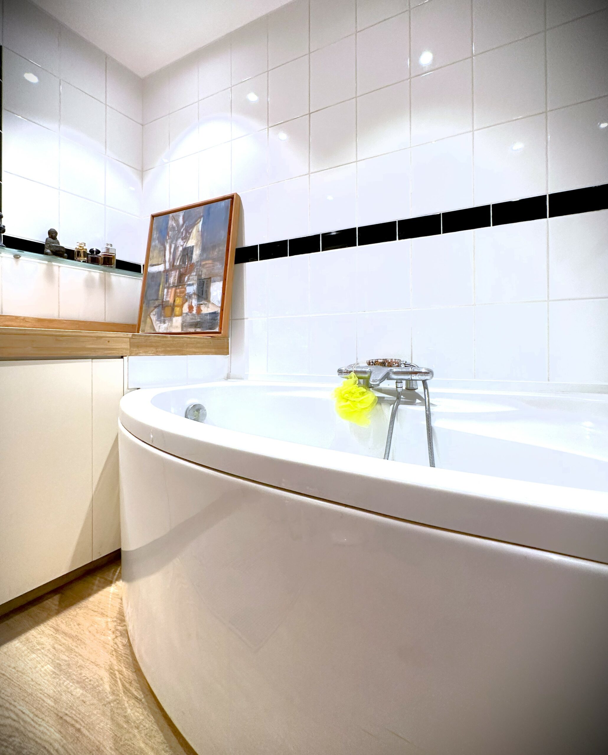 Vue plongeant sur une baignoire ronde et blanche dans une salle de bain